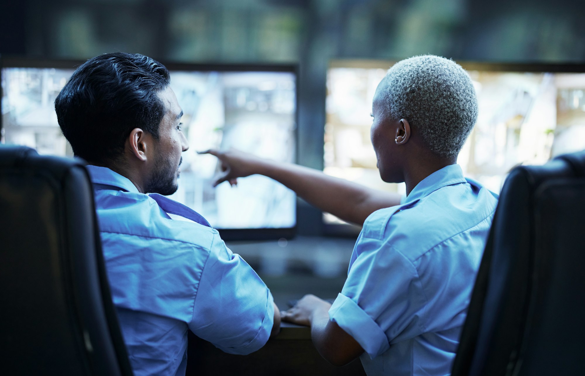 Security guard in control room, man and woman with screen to check cctv together in team office. Sa